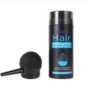 Hair building fibers bottle beside a black applicator brush.