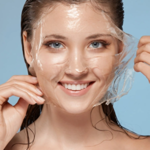 Woman lifting a transparent gel face mask from her face.