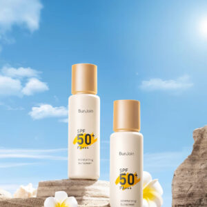 Two sunscreen bottles labeled SPF 50+ displayed on rocks against a blue sky.