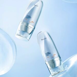 Two white and blue sunscreen bottles displayed against a watery blue background.