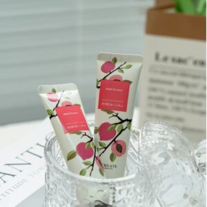 Two hand cream tubes with colorful botanical labels in a glass bowl.