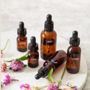Amber essential oil dropper bottles arranged with small flowers.
