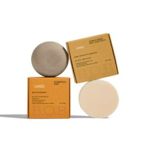 Two round shampoo and conditioner bars beside brown cartons.