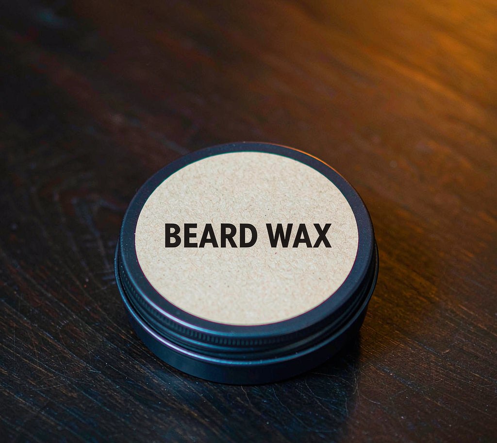 Beard wax tin with product label on dark wood