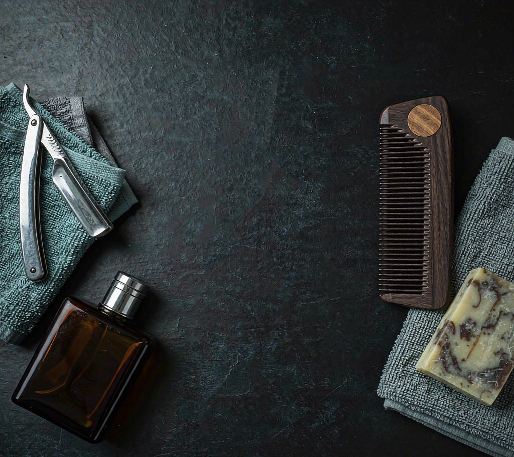 Men's grooming essentials flat lay with comb, razor and soap
